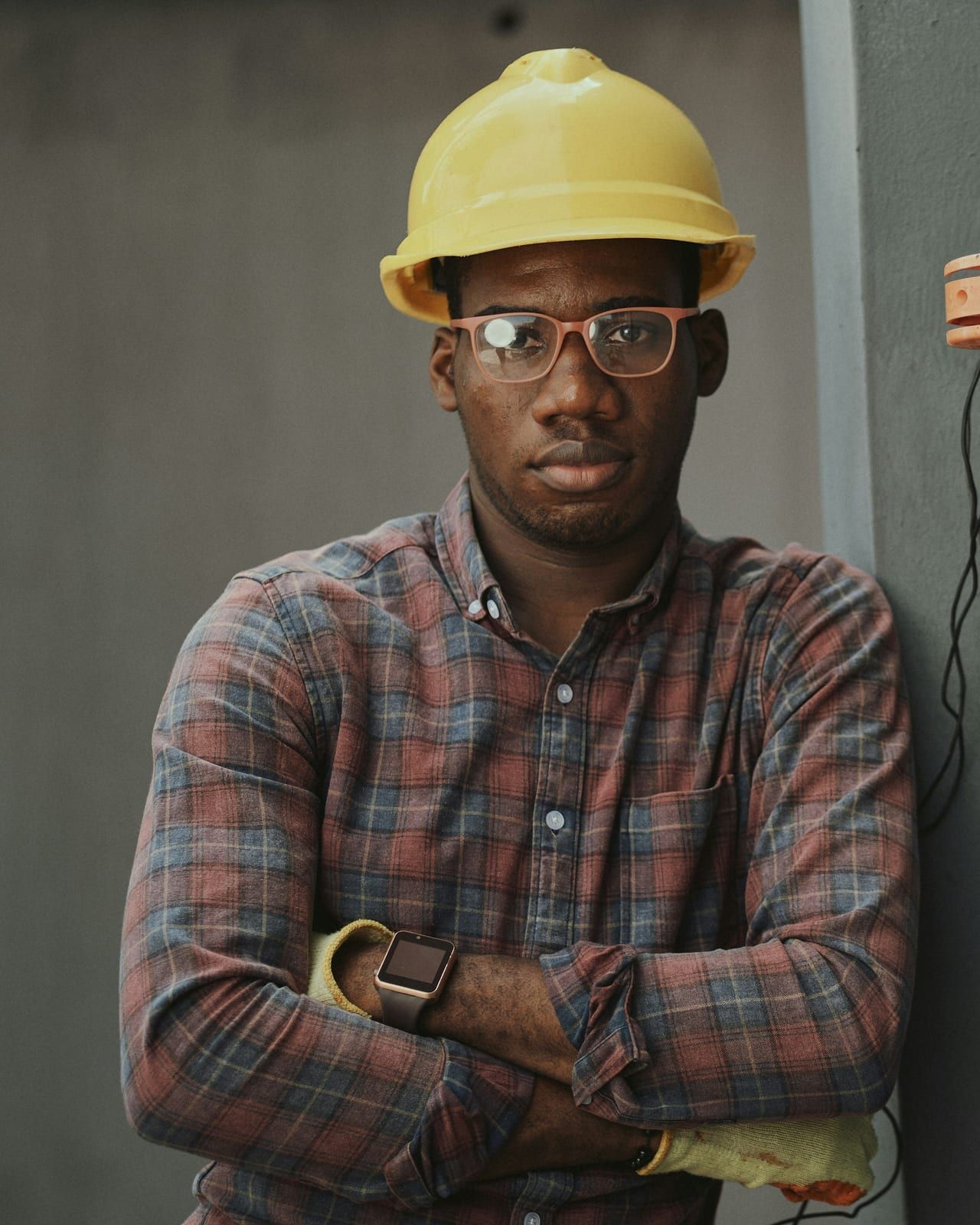 A Circle City technician in a hard hat and safety glasses, arms crossed at an electrical panel.